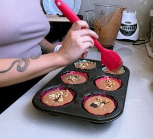 Add the chopped chocolate and walnuts to each cupcake mold